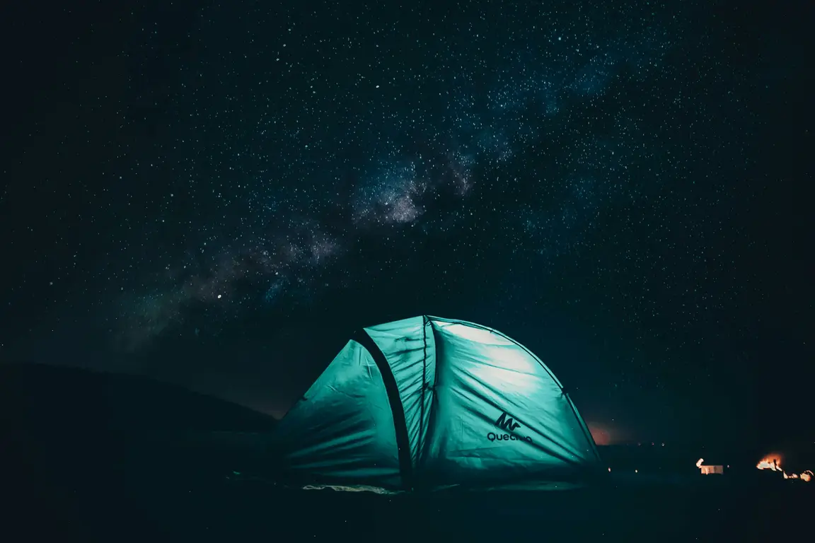 星空の下で明かりの灯るテント